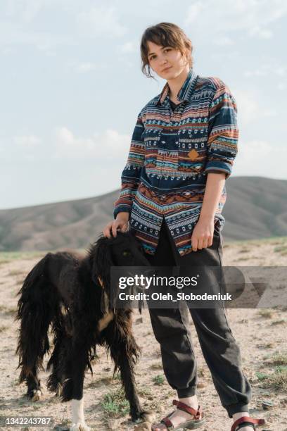 frau mit hund in der steppe - kyrgyzstan stock-fotos und bilder