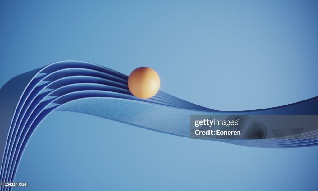 Orangefarbene Kugel, die auf welligen Bändern steht
