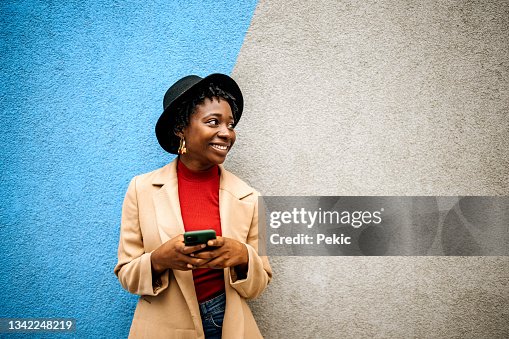 Young casually clothed woman posing in front of coloured wall Young casually clothed woman posing in front of coloured wall