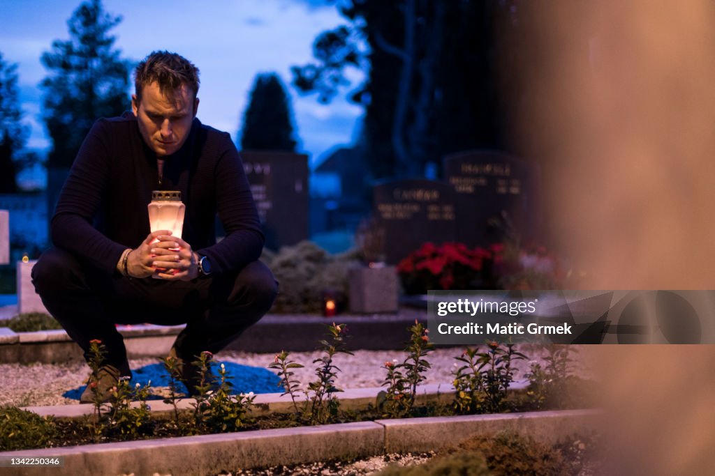 Lighting candles by the grave
