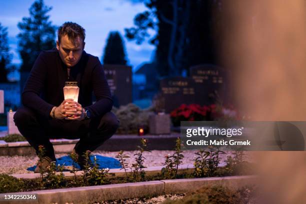 lighting candles by the grave - mourning candles stock pictures, royalty-free photos & images