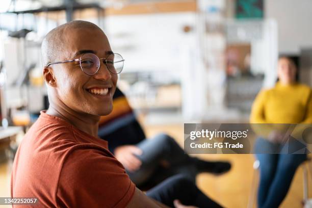 portrait of a young man in group therapy at a coworking - portraits of liberians who recovered from ebola stockfoto's en -beelden