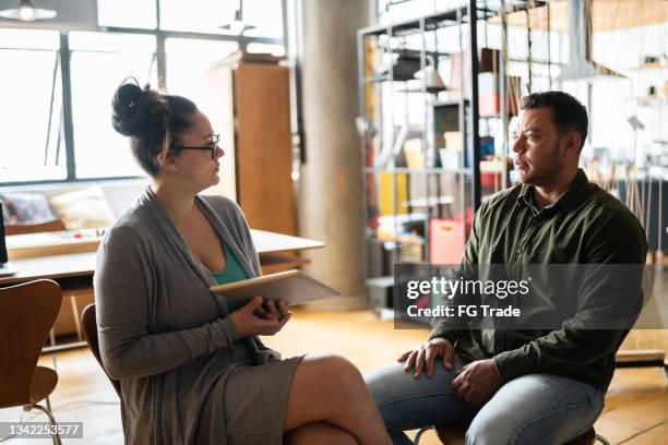 mature psychologist with a transgender man at a coworking - employee feedback stock pictures, royalty-free photos & images