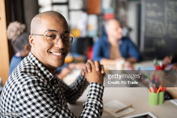 porträt eines jungen mannes bei einem meeting bei einem coworking - internship marketing stock-fotos und bilder