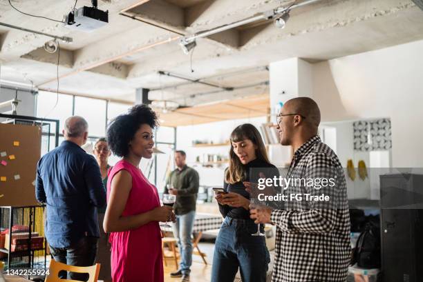 colegas hablando después del trabajo en un coworking - fiesta en la oficina fotografías e imágenes de stock