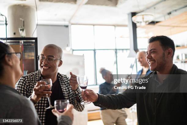 colleagues toasting after work at a coworking - including transgender person - office party stockfoto's en -beelden