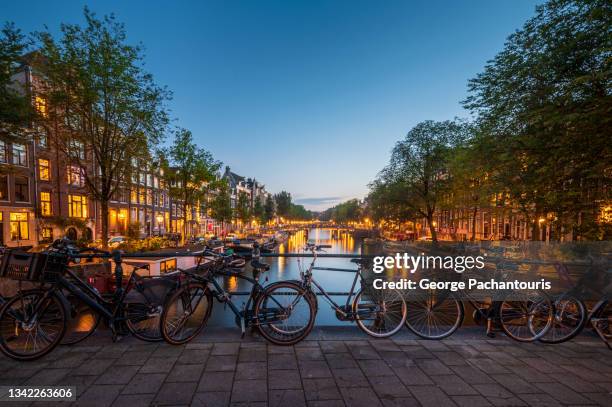 bicycles on a bridge in amsterdam at dusk - amsterdam night stock pictures, royalty-free photos & images