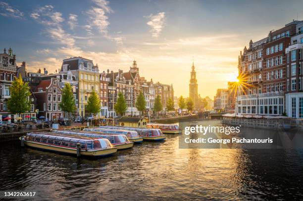 sunset in amsterdam with the muntorren standing out - amsterdam canals stockfoto's en -beelden