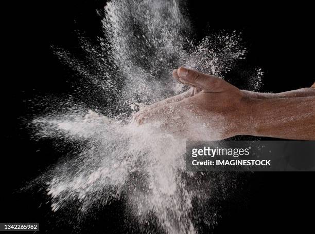 close-up of hands shaking flour - action cooking fotografías e imágenes de stock