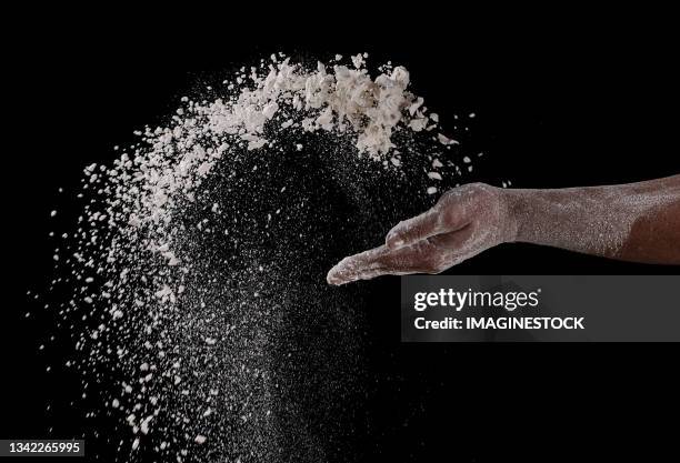 close-up of a hand throwing flour on a black background - black and white food 個照片及圖片檔