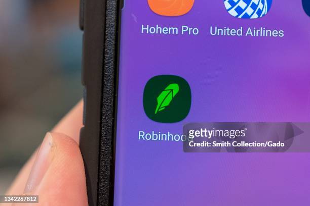 Close-up of human hand holding a cellphone displaying icon for the investment app Robinhood, Lafayette, California, September 15, 2021.