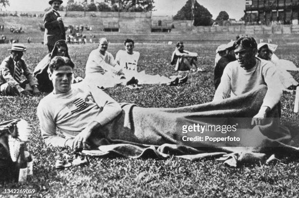 American athlete Robert LeGendre relaxing with a blanket over his legs after setting a new long jump world record in the men's pentathlon competition...