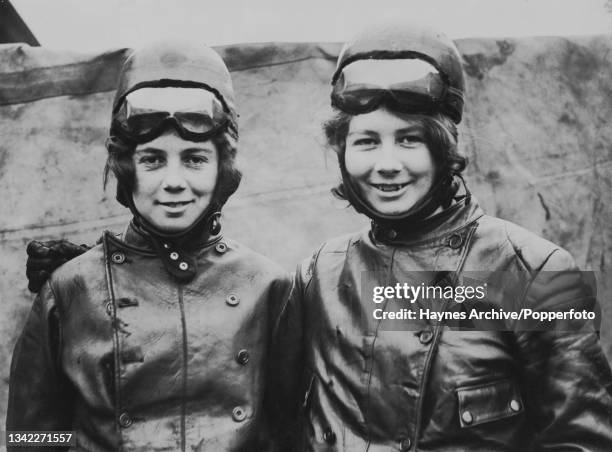 British motorcycle racers Joan Archer and her twin sister, Thelma Archer, both wearing leather jackets and crash helmets with goggles raised, in...