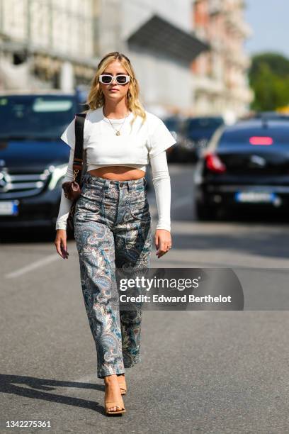 Valentina Ferragni wears a gold long necklace, a gold large chain necklace, a white cropped t-shirt, a white long sleeves cropped t-shirt, a brown...