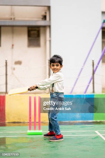 cute indian little child playing cricket at playground. - cricket player stockfoto's en -beelden