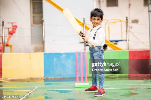 cute indian little child playing cricket at playground. - cricket player stockfoto's en -beelden