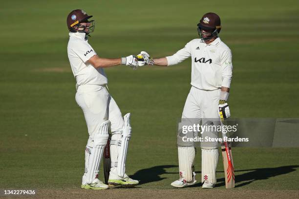 Rikki Clarke of Surrey fist bumps with Ben Foakes in his final appearance on day four during the LV= Insurance County Championship match between...