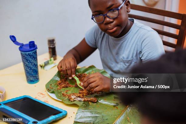 young kids having dinner at home with the family,tema,ghana - ghanaian family stock-fotos und bilder