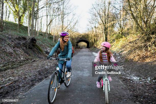 hobbys in der familie - child and parent and bike stock-fotos und bilder