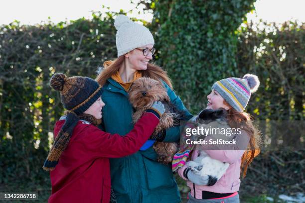 happy family with their pet dogs - bobble hat stock pictures, royalty-free photos & images