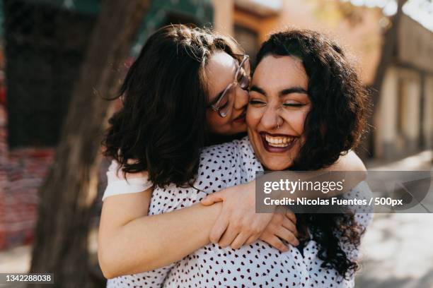 young lesbian couple embracing outdoors in city,santiago de chile,chile - lesbian couple fotografías e imágenes de stock