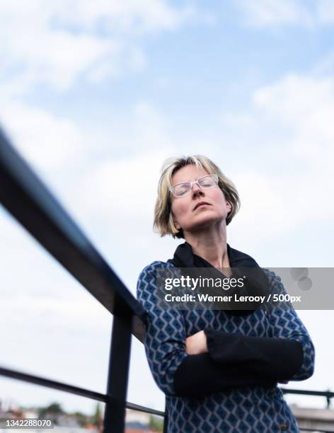 portrait of mature woman standing against sky,jette,belgium - jette stock pictures, royalty-free photos & images