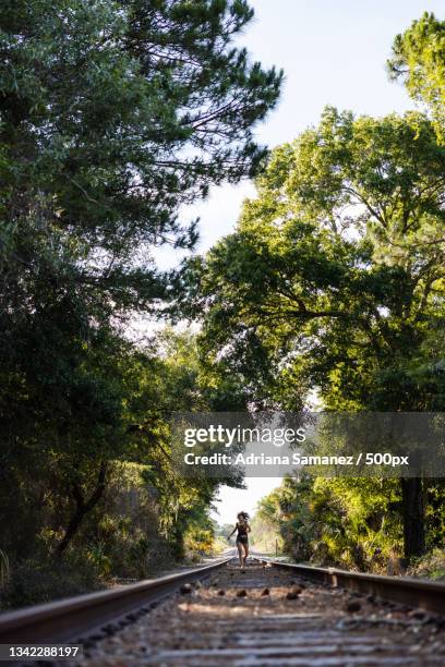 happy young woman having fun on railroad tracks,gainesville,florida,united states,usa - gainesville florida stock pictures, royalty-free photos & images