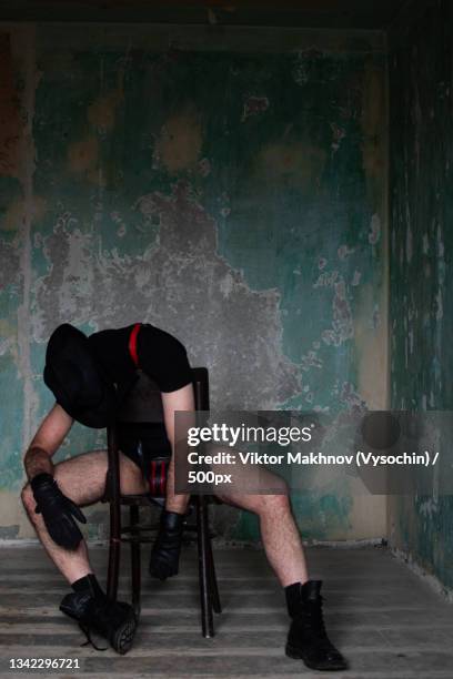 man sitting on chair against wall,kharkiv,kharkiv oblast,ukraine - fetisj stock pictures, royalty-free photos & images