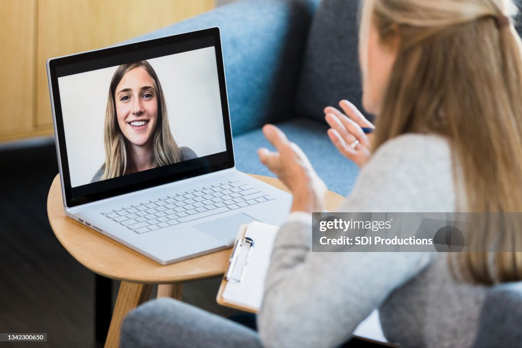 Therapist gives advice to young woman during online therapy session
