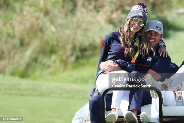 Brooks Koepka of team United States and wife Jena Sims ride off on a cart during Friday Morning Foursome Matches of the 43rd Ryder Cup at Whistling...