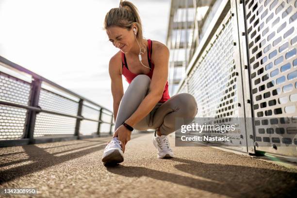 sportswoman with injured ankle making a painful face - sport injury stock pictures, royalty-free photos & images