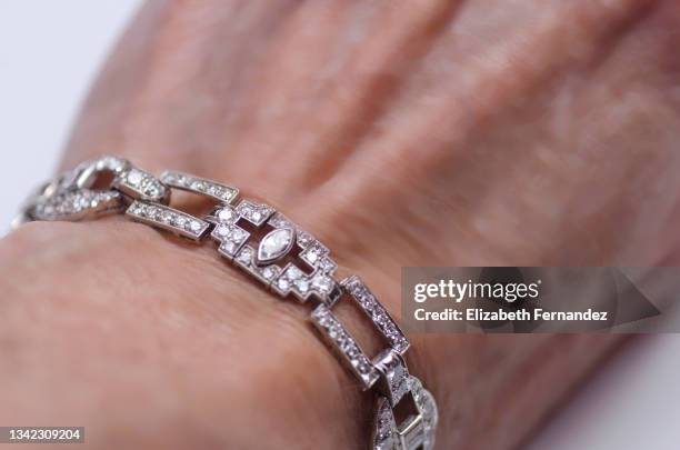woman's hand wearing platinum and diamond bracelet - diamond bangle stock pictures, royalty-free photos & images