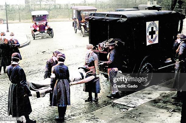 Members of the Motor Corps of the American Red Cross perform ambulance duty while wearing cloth face masks during the 1918 influenza pandemic, Saint...