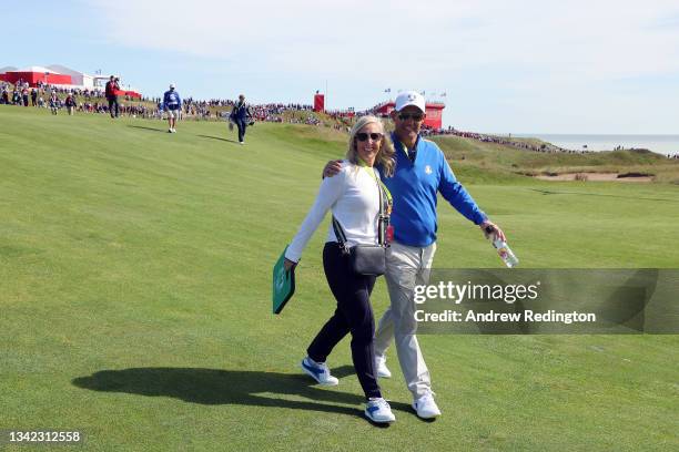 Captain Padraig Harrington of Ireland and team Europe and wife Caroline Harrington walk across the course during Friday Morning Foursome Matches of...