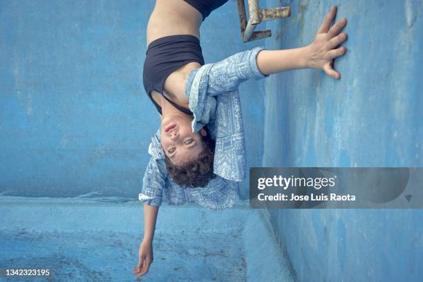 a young woman staring into an empty swimming pool - hallenbad leer stock-fotos und bilder