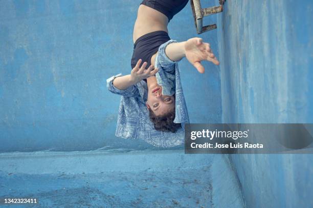 girl in an empty pool. woman on a luxury outdoors empty swimming pool in a modern house - hallenbad leer stock-fotos und bilder