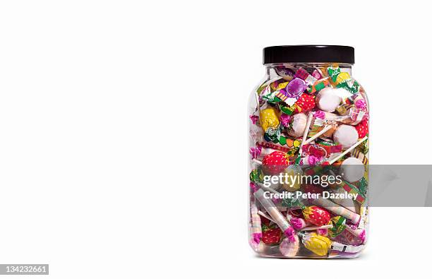 jar of sweets on white background - süßigkeit stock-fotos und bilder