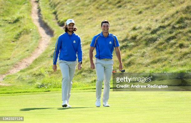 Tommy Fleetwood of England and team Europe and Viktor Hovland of Norway and team Europe walk across the seventh green during Friday Afternoon...