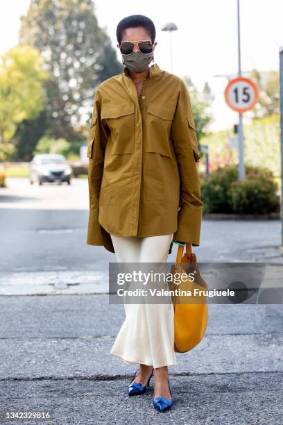 Tamu McPherson outside Sportmax fashion show wearing an oversized shirt, cream satin skirt and yellow oversized bag during the Milan Fashion Week -...