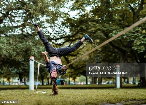 giovane che pratica acro yoga sulla linea slack nel parco - slackline foto e immagini stock