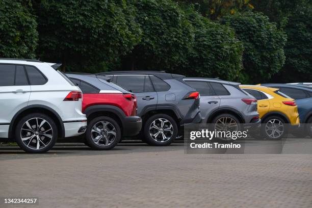 elektro- und plug-in-hybridfahrzeuge auf einem öffentlichen parkplatz auf einer straße - car fleet stock-fotos und bilder