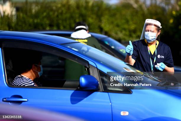 Volunteer assists people attending the Cook Islands drive through vaccination community event on September 25, 2021 in Auckland, New Zealand. Pacific...