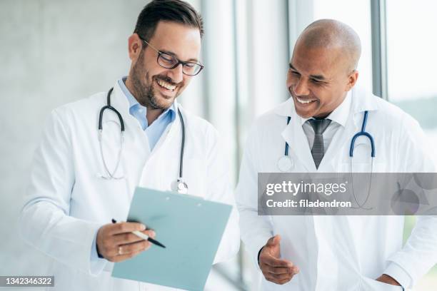 two doctors talking at hospital - medical chart stock pictures, royalty-free photos & images