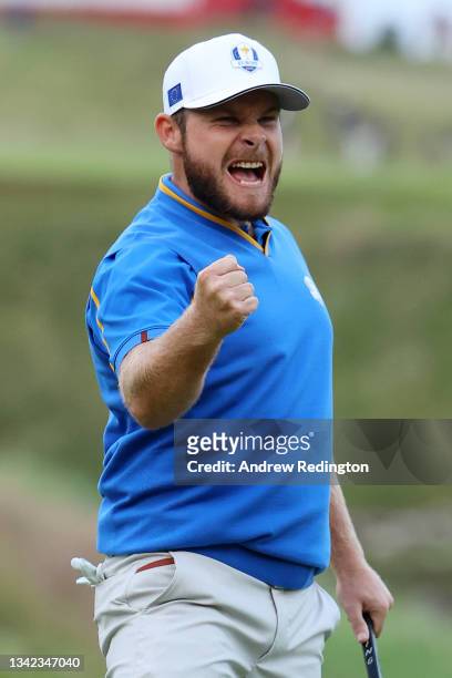 Tyrrell Hatton of England and team Europe reacts to his birdie on the 18th green to halve the match between Hatton, Jon Rahm of Spain and team...