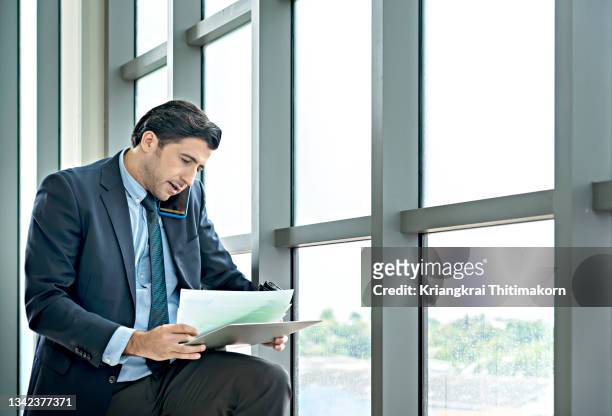 a businessman is busy working, talking and reading paper. - business people and paper imagens e fotografias de stock