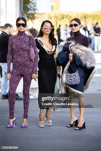 Gilda Ambrosio, wearing a purple printed jumpsuit, Amina Muaddi and Giorgia Tordini, pose ahead of the Prada fashion show during the Milan Fashion...