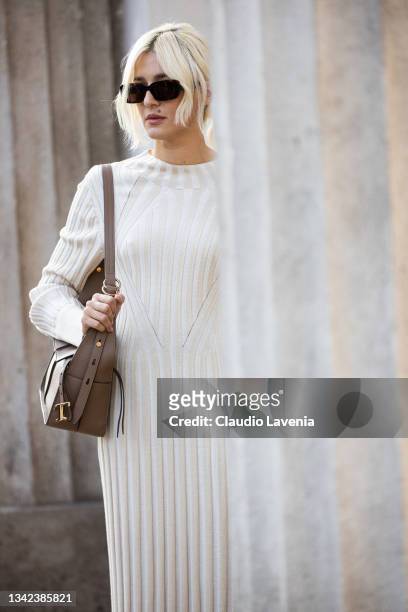 Eleonora Carisi, wearing white dress and brown bag, poses ahead of the Tods fashion show during the Milan Fashion Week - Spring / Summer 2022 on...