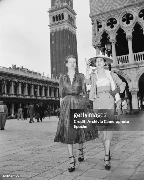 Two women modelling Christian Dior outfits, on the Piazza San Marco in Venice, 3rd June 1951. In the background is St Mark's Campanile.