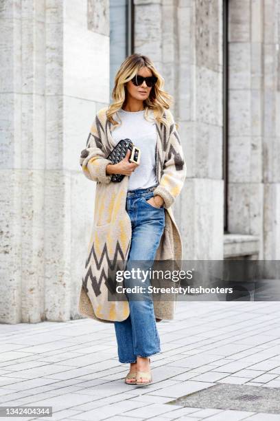 Influencer Gitta Banko wearing a long cardigan in earthtones with zigzag pattern by Delicate Love, a grey t-shirt by Zara, blue denim jeans pants by...