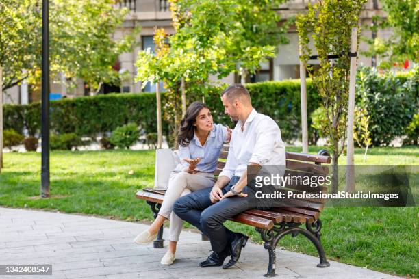 ein modernes junges paar ist unglücklich und hat einen ernsthaften streit in einem park. - business confuse conflict stock-fotos und bilder